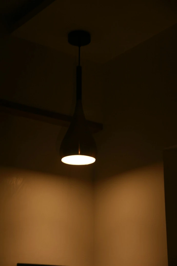 A dark room with a ceiling fan and a light